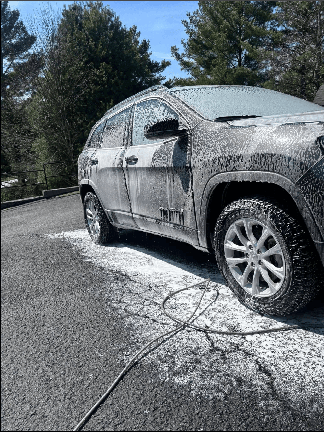 Jeep SUV covered in thick snow foam during a mobile exterior detail in a south Johnson County driveway